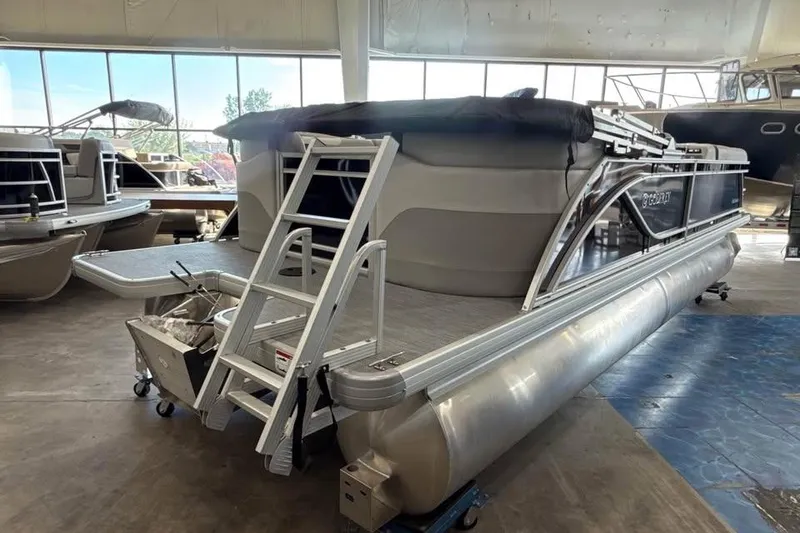 Slide: The Image of 2026 Godfrey Sweetwater 2286 SB pontoon boat in showroom, featuring sleek design and ladder access. - 7