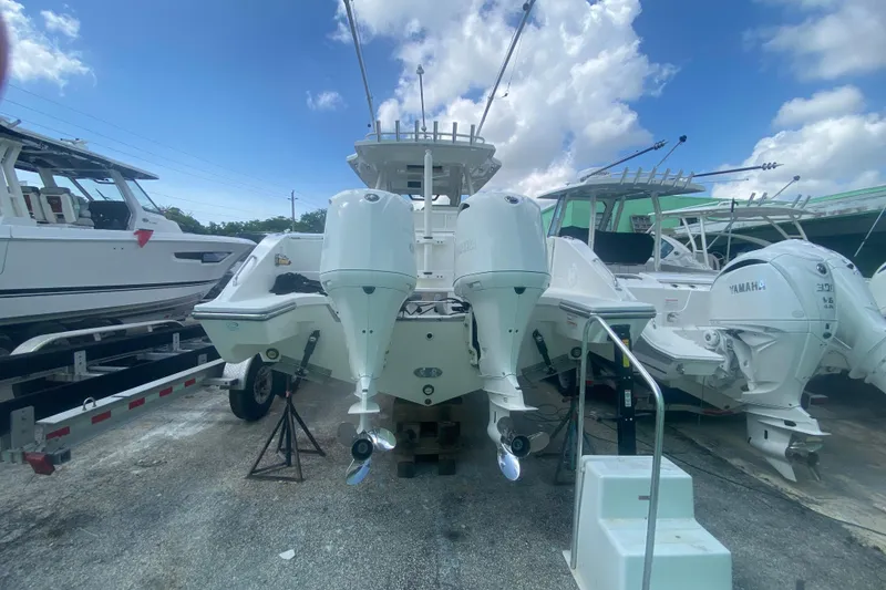 Slide: The Image of 2019 Pursuit S 328 Sport boat with dual Yamaha outboard engines, docked under a blue sky. - 1