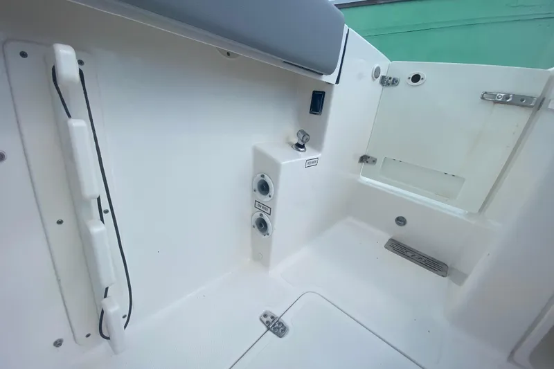Slide: The Image of 2019 Pursuit S 328 Sport boat interior, featuring clean white surfaces and utility fixtures. - 11