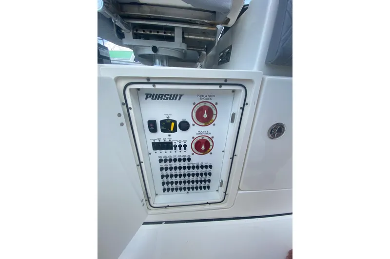 Slide: The Image of Control panel of a 2019 Pursuit S 328 Sport boat, featuring engine and generator switches. - 24