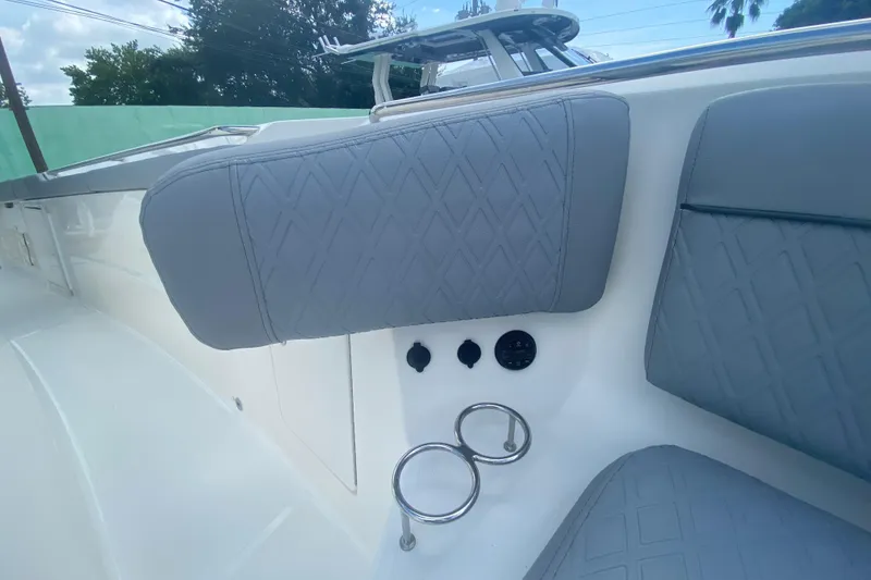 Slide: The Image of 2019 Pursuit S 328 Sport boat interior with gray cushioned seating and cup holders. - 30