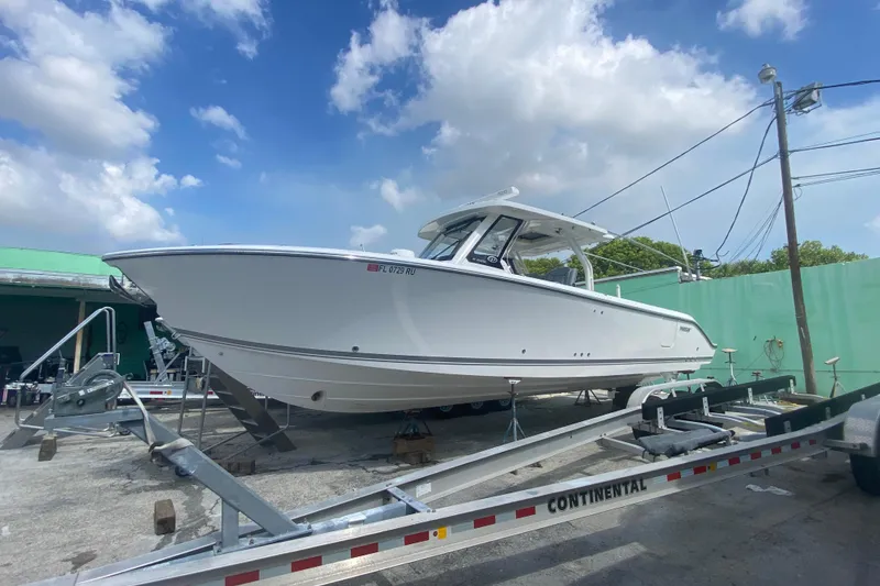The Image of 2019 Pursuit S 328 Sport boat on trailer under blue sky. - 0