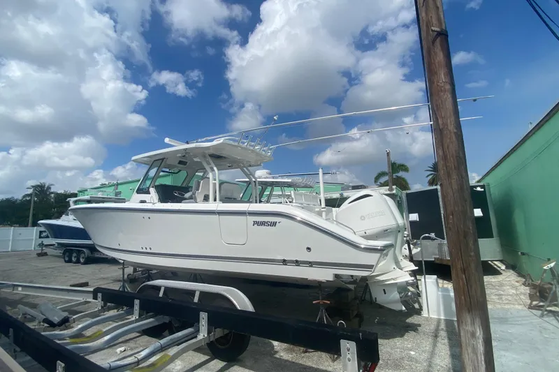 Slide: The Image of 2019 Pursuit S 328 Sport boat on trailer under a partly cloudy sky. - 3