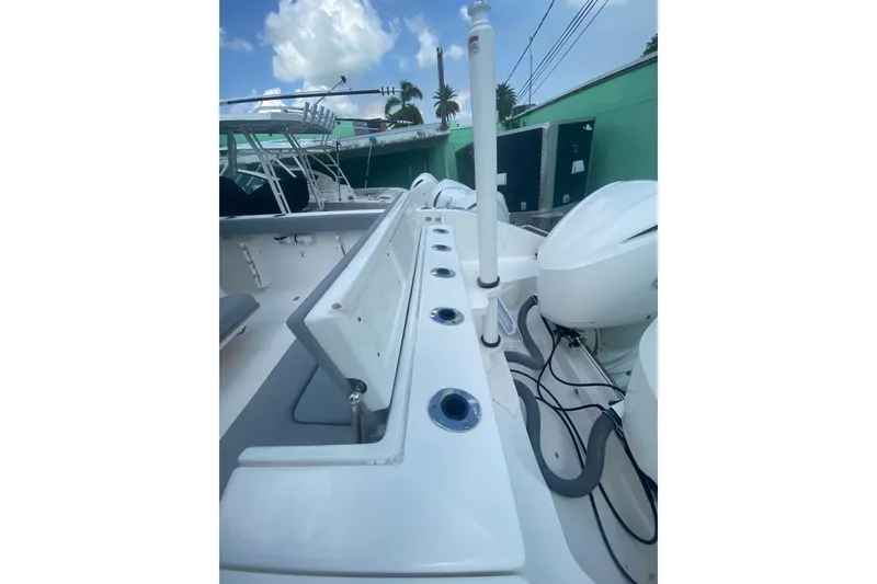 Slide: The Image of 2019 Pursuit S 328 Sport boat deck with rod holders and dual engines. - 17