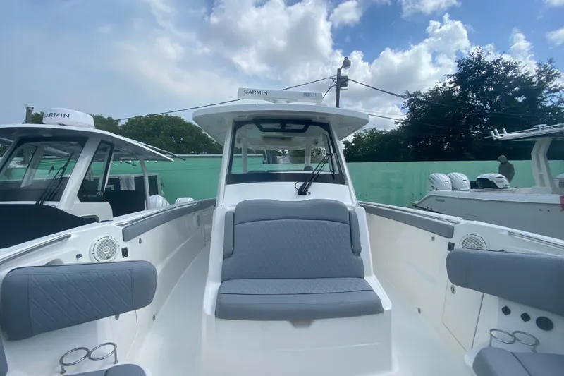Slide: The Image of 2019 Pursuit S 328 Sport boat with spacious seating and modern design under a cloudy sky. - 28