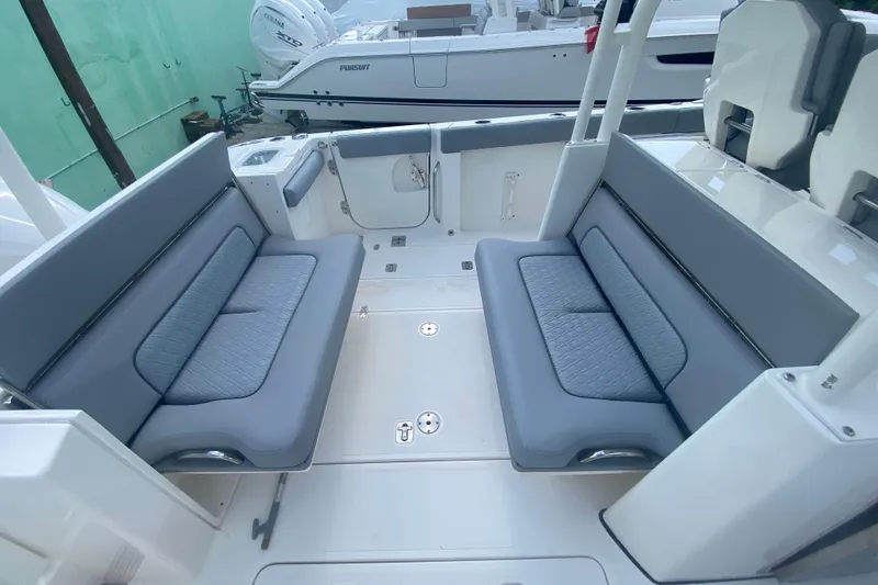 Slide: The Image of 2019 Pursuit S 328 Sport boat interior with gray cushioned seating and sleek design. - 13