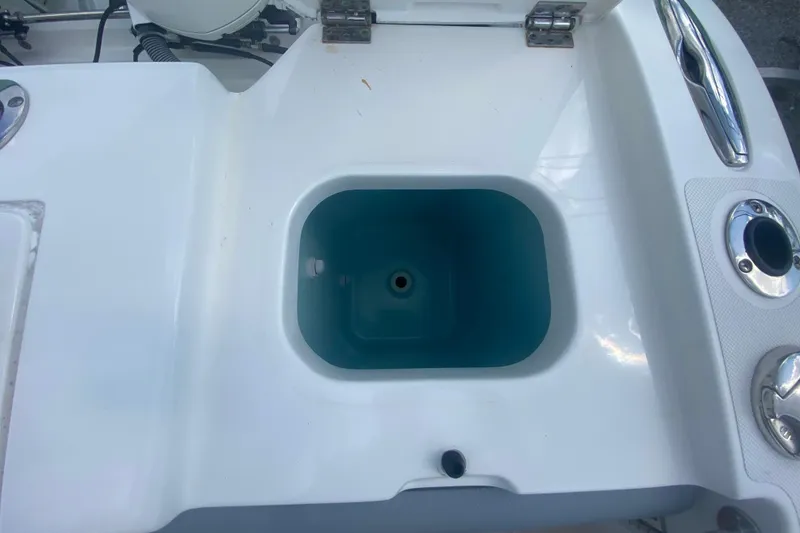 Slide: The Image of Livewell compartment on a 2019 Pursuit S 328 Sport boat, featuring stainless steel fixtures. - 15