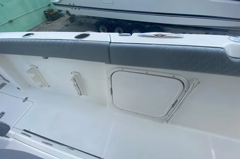 Slide: The Image of 2019 Pursuit S 328 Sport boat interior with cushioned seating and storage compartment. - 20