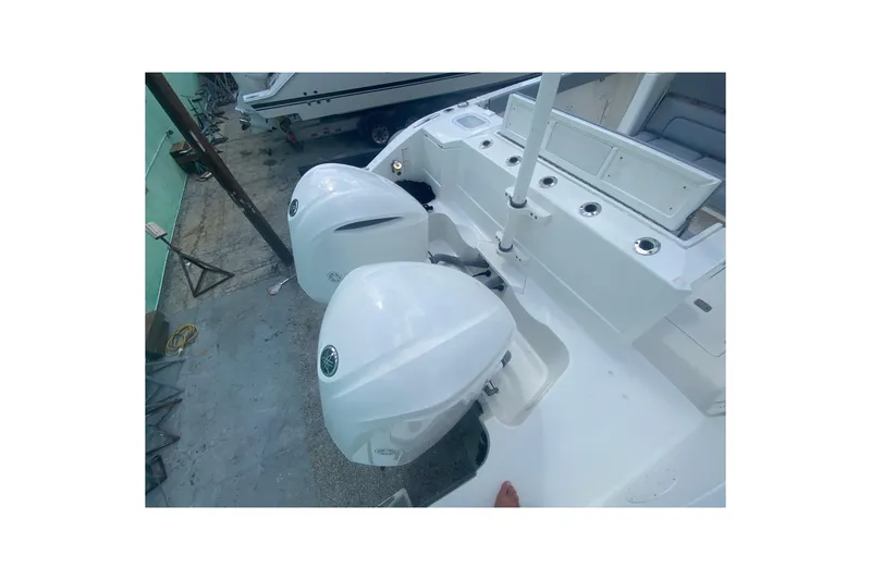 Slide: The Image of 2019 Pursuit S 328 Sport boat with dual outboard engines, docked in a marina. - 7