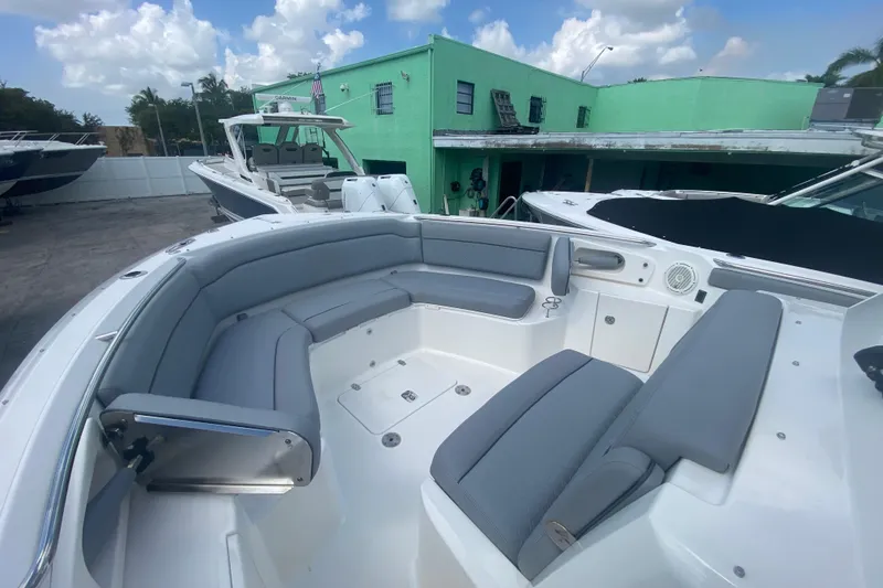 Slide: The Image of 2019 Pursuit S 328 Sport boat with spacious seating, docked under a cloudy sky. - 27