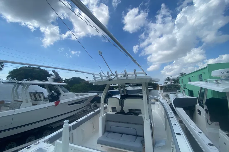 Slide: The Image of 2019 Pursuit S 328 Sport boat docked under a partly cloudy sky. - 9