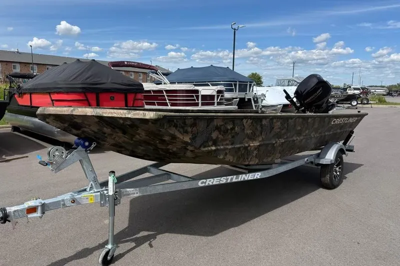 The Image of 2027 Crestliner 1760 Retriever Jon boat on trailer, camo design, parked outdoors. - 0