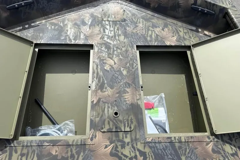 Slide: The Image of 2027 Crestliner 1760 Retriever Jon boat with open storage compartments and camouflage design. - 9