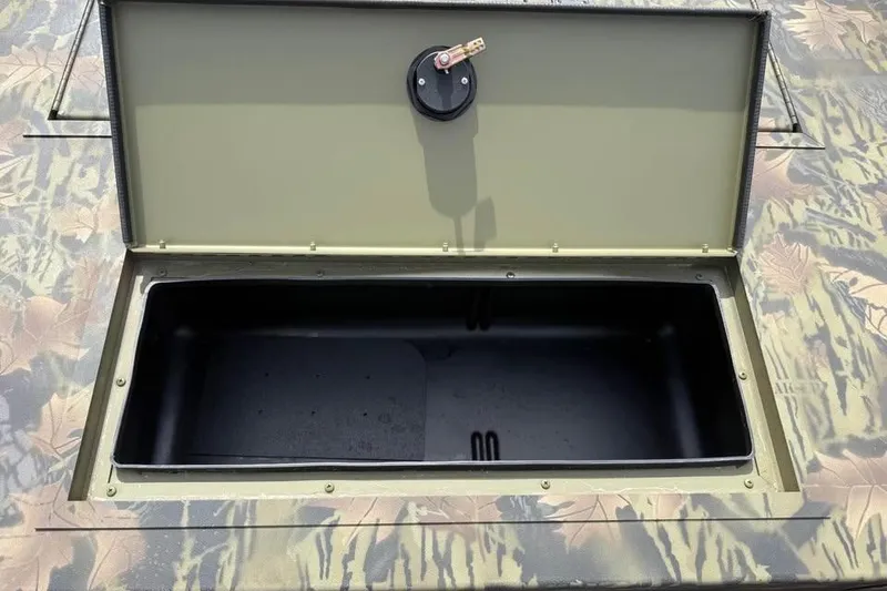 Slide: The Image of Open storage compartment of 2027 Crestliner 1760 Retriever Jon boat with camouflage pattern. - 7