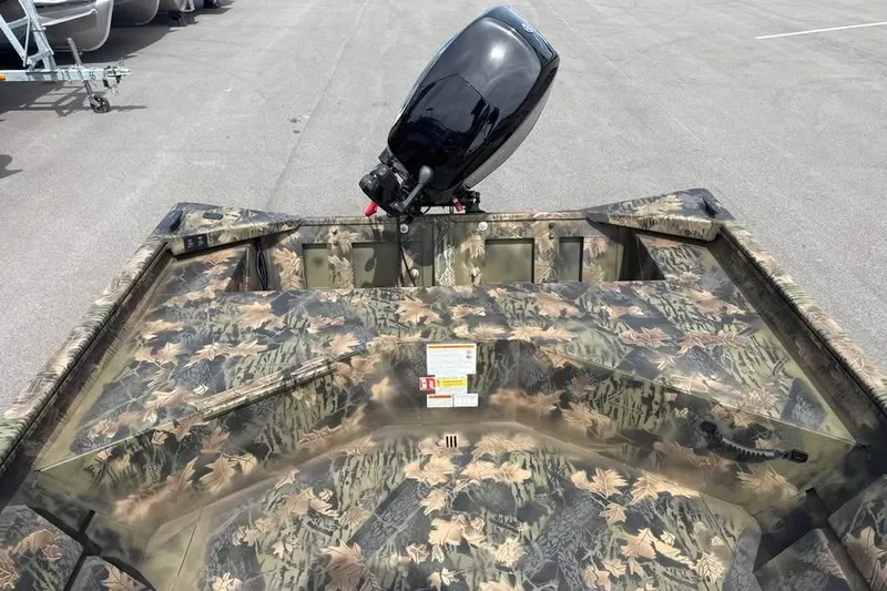 Slide: The Image of 2027 Crestliner 1760 Retriever Jon boat with camouflage design and outboard motor. - 6
