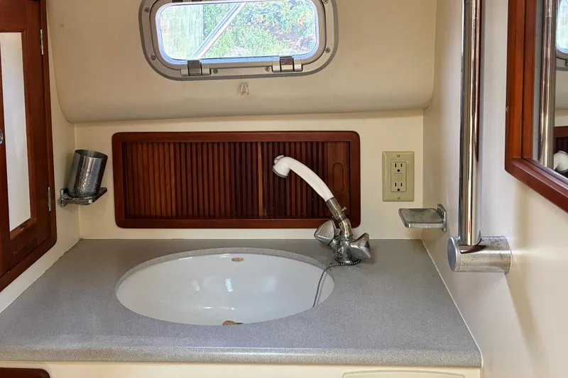 Slide: The Image of Little Harbor WhisperJet 40 (2000) bathroom sink with faucet and porthole window. - 45