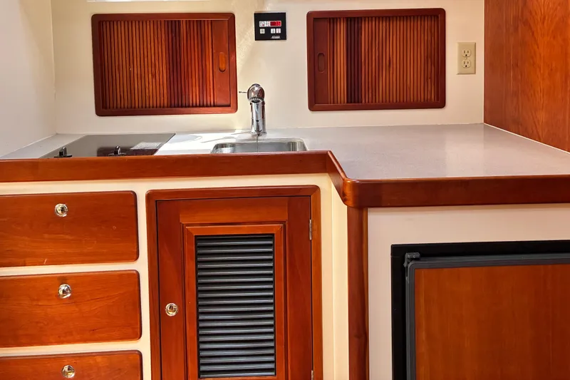 Slide: The Image of Wooden interior of 2000 Little Harbor WhisperJet 40 yacht kitchen with sink and cabinets. - 31