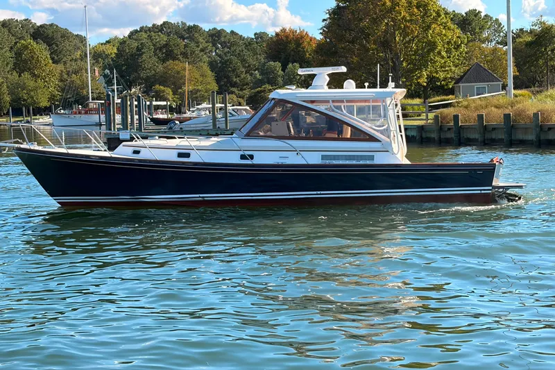 The Image of Little Harbor WhisperJet 40, 2000 model, cruising on calm waters near a marina. - 0