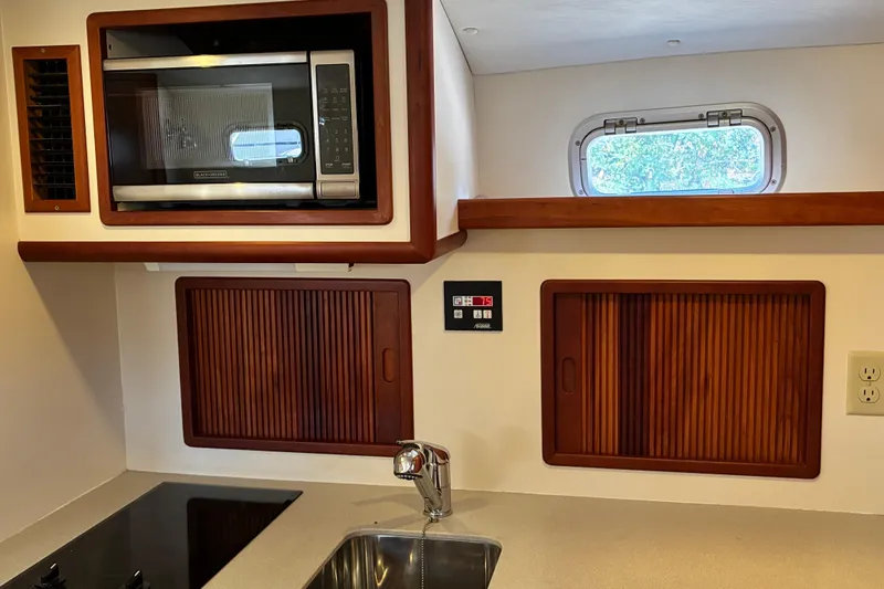 Slide: The Image of Little Harbor WhisperJet 40 (2000) galley with microwave, stove, and wooden cabinets. - 24