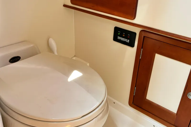 Slide: The Image of Boat bathroom with VacuFlush toilet, wooden cabinet, and control panel in 2000 Little Harbor WhisperJet 40. - 47