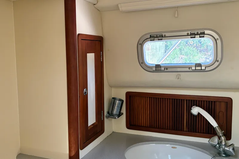 Slide: The Image of Little Harbor WhisperJet 40 (2000) bathroom with wooden cabinetry and porthole window. - 46