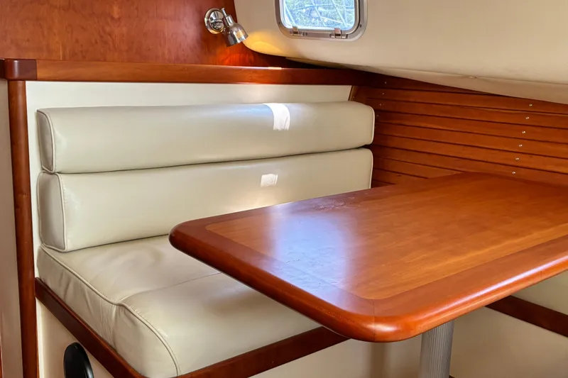 Slide: The Image of Interior of 2000 Little Harbor WhisperJet 40 with wooden table and cream seating. - 35
