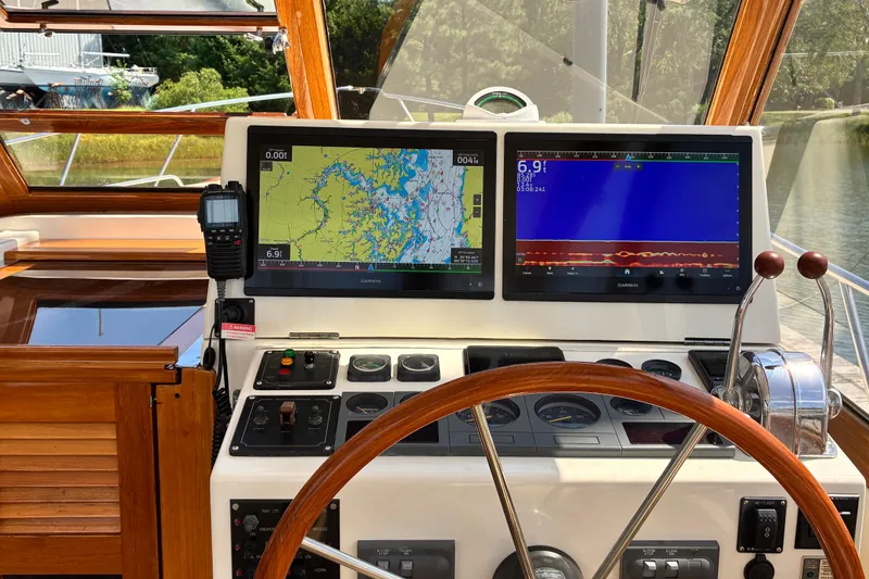 Slide: The Image of Helm of 2000 Little Harbor WhisperJet 40 with navigation screens and wooden steering wheel. - 13