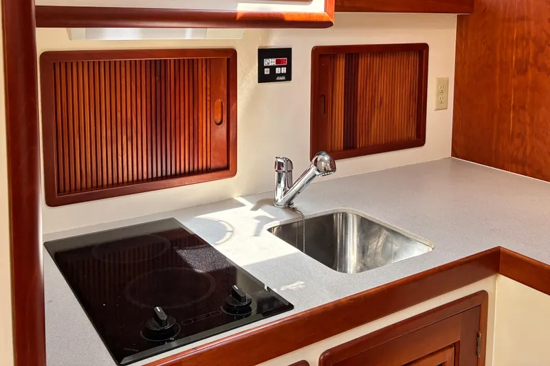 Slide: The Image of Little Harbor WhisperJet 40 (2000) yacht kitchen with stove, sink, and wooden cabinetry. - 28