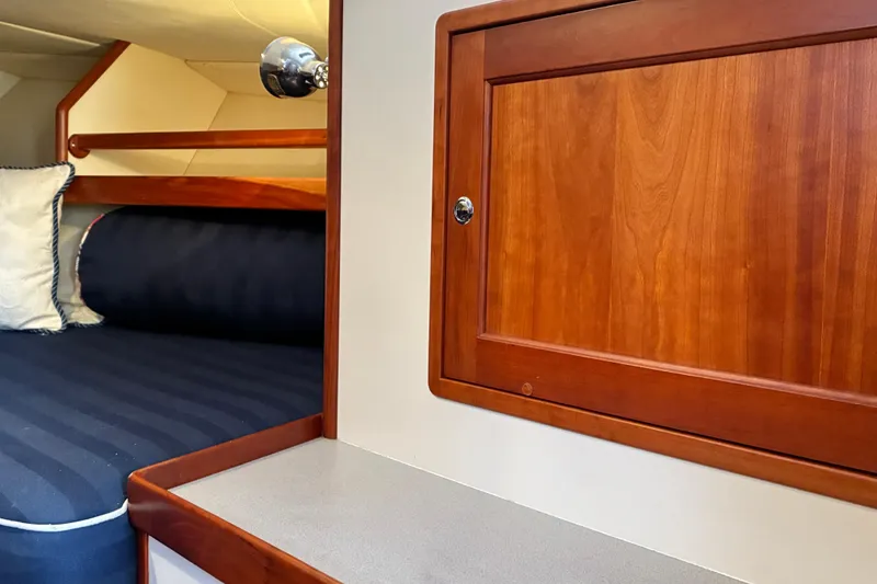 Slide: The Image of Cozy cabin interior of 2000 Little Harbor WhisperJet 40 with wooden cabinetry and striped bedding. - 43