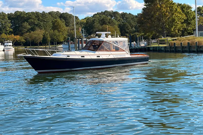 Slide: The Image of 2000 Little Harbor WhisperJet 40 yacht cruising on a serene lake with lush greenery. - 1