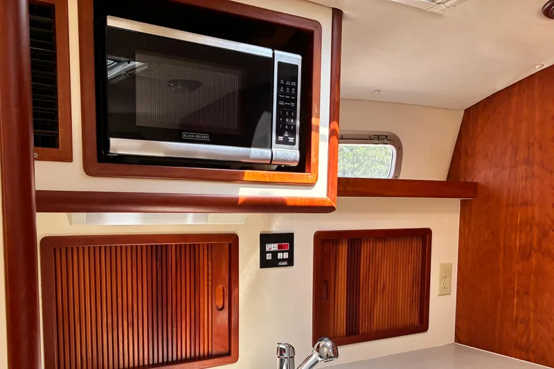 Slide: The Image of Interior of 2000 Little Harbor WhisperJet 40 with microwave and wooden cabinetry. - 27