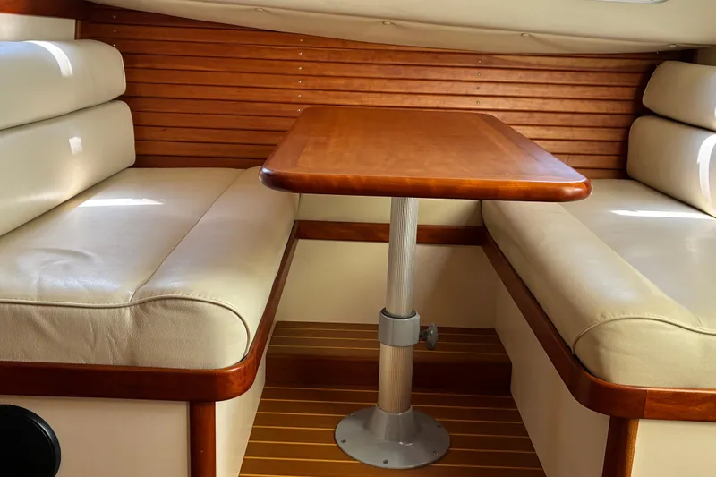 Slide: The Image of Interior of 2000 Little Harbor WhisperJet 40 with wooden table and cushioned seating. - 36
