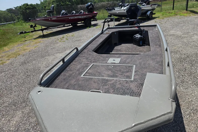 Slide: The Image of 2024 Gator Tail Extreme series boat on gravel, with other boats in the background. - 10