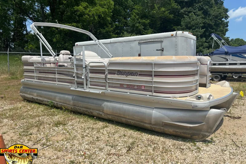 The Image of 2003 Sanpan 2200 LE pontoon boat parked on gravel near trees. - 1