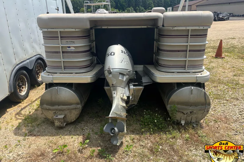 Slide: The Image of 2003 Sanpan 2200 LE pontoon boat with Honda 50 outboard motor, parked on gravel. - 4