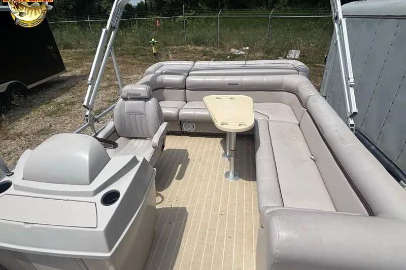 Slide: The Image of 2003 Sanpan 2200 LE pontoon boat interior with beige seating and table. - 9
