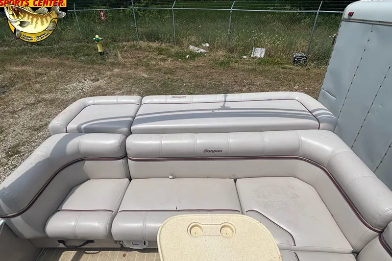 Slide: The Image of 2003 Sanpan 2200 LE boat interior with beige seating and outdoor setting. - 10