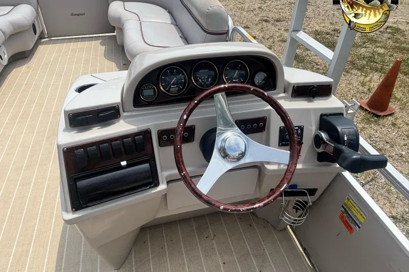 Slide: The Image of 2003 Sanpan 2200 LE boat dashboard with steering wheel and control panel. - 7