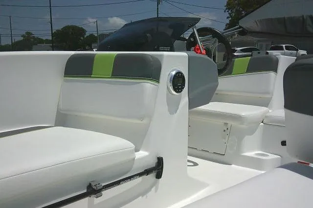 Slide: The Image of 2022 Tahoe T16 boat interior with white and green seating, steering wheel, and dashboard. - 18