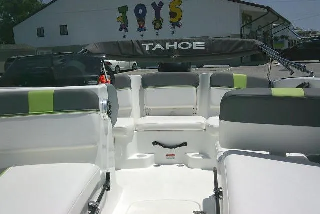 Slide: The Image of 2022 Tahoe T16 boat interior with white and green seating, parked near a building. - 17