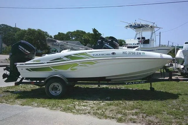 The Image of 2022 Tahoe T16 boat on trailer with green accents, parked outdoors. - 0
