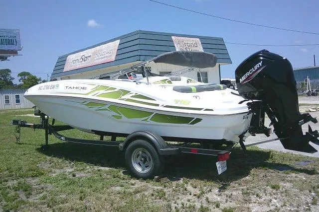 Slide: The Image of 2022 Tahoe T16 boat with Mercury engine on trailer, parked outdoors. - 2
