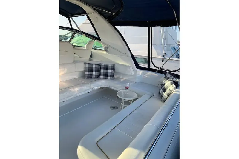 Slide: The Image of 1999 Sea Ray Sundancer 400 yacht interior with white seating and plaid pillows. - 19