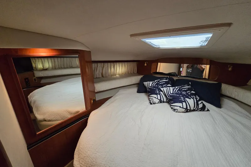 Slide: The Image of Interior cabin of 1999 Sea Ray Sundancer 400 with cozy bedding and decorative pillows. - 12