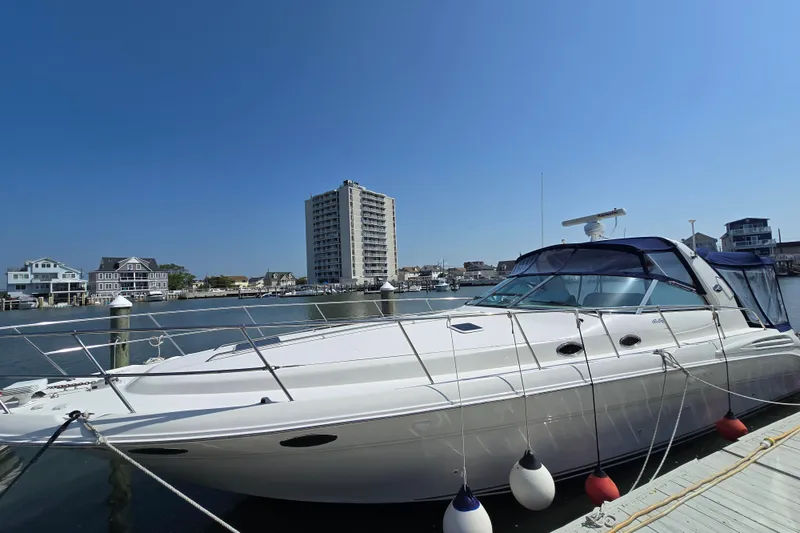 Slide: The Image of 1999 Sea Ray Sundancer 400 yacht docked in a marina with waterfront buildings in the background. - 3