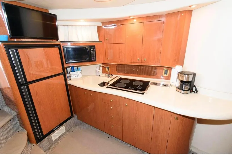 Slide: The Image of Luxurious 1999 Sea Ray Sundancer 400 yacht kitchen with modern appliances and elegant wood cabinetry. - 6