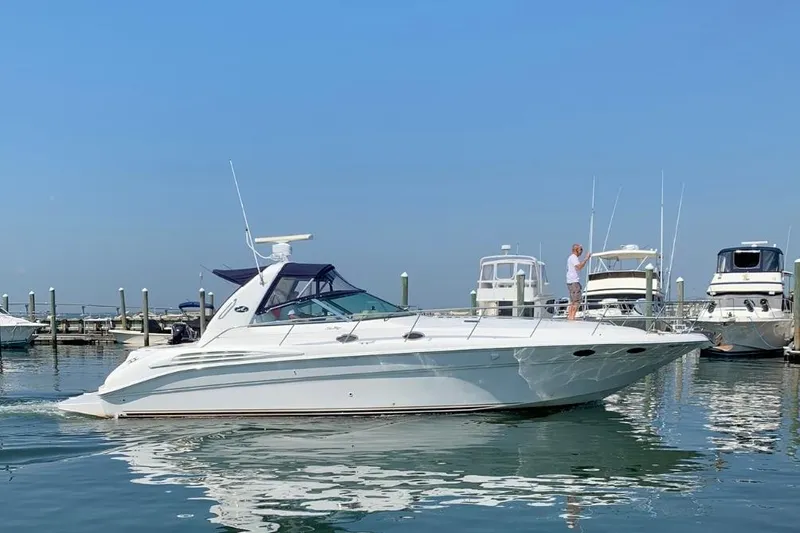 The Image of 1999 Sea Ray Sundancer 400 yacht docked in a marina under clear blue skies. - 0