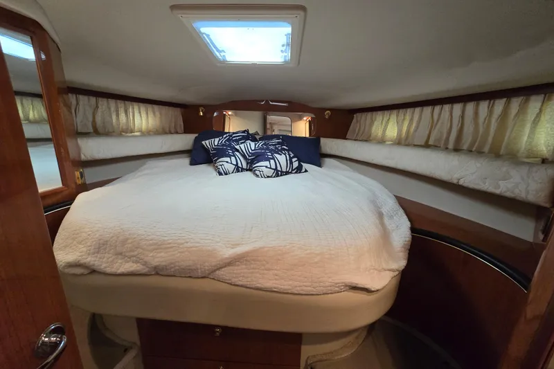 Slide: The Image of 1999 Sea Ray Sundancer 400 cabin with cozy bed, pillows, and natural light. - 10