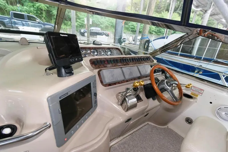 Slide: The Image of Cockpit of a 1999 Sea Ray Sundancer 400 with navigation equipment and wooden steering wheel. - 16