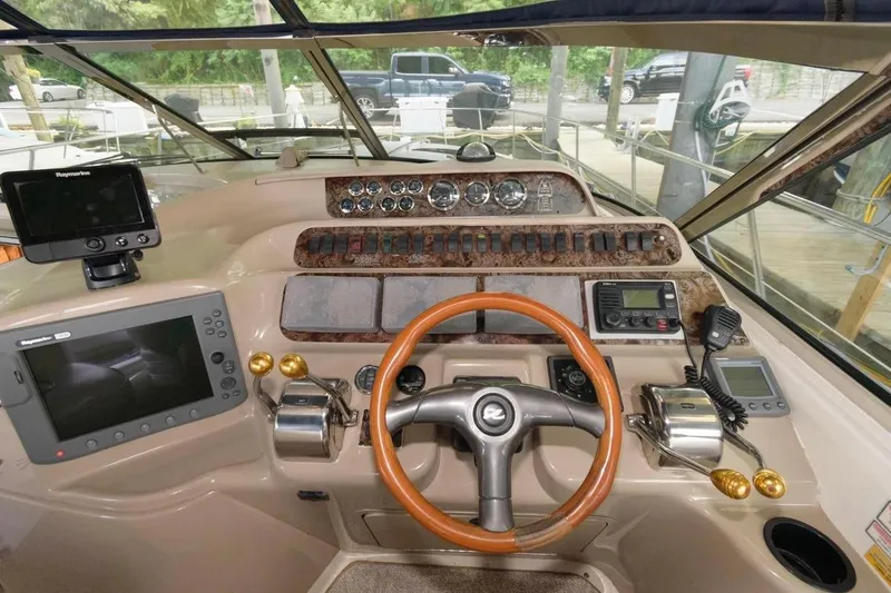 Slide: The Image of 1999 Sea Ray Sundancer 400 helm with navigation equipment and wooden steering wheel. - 15